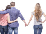 Man embrace his girlfriend while holding hands another girl.